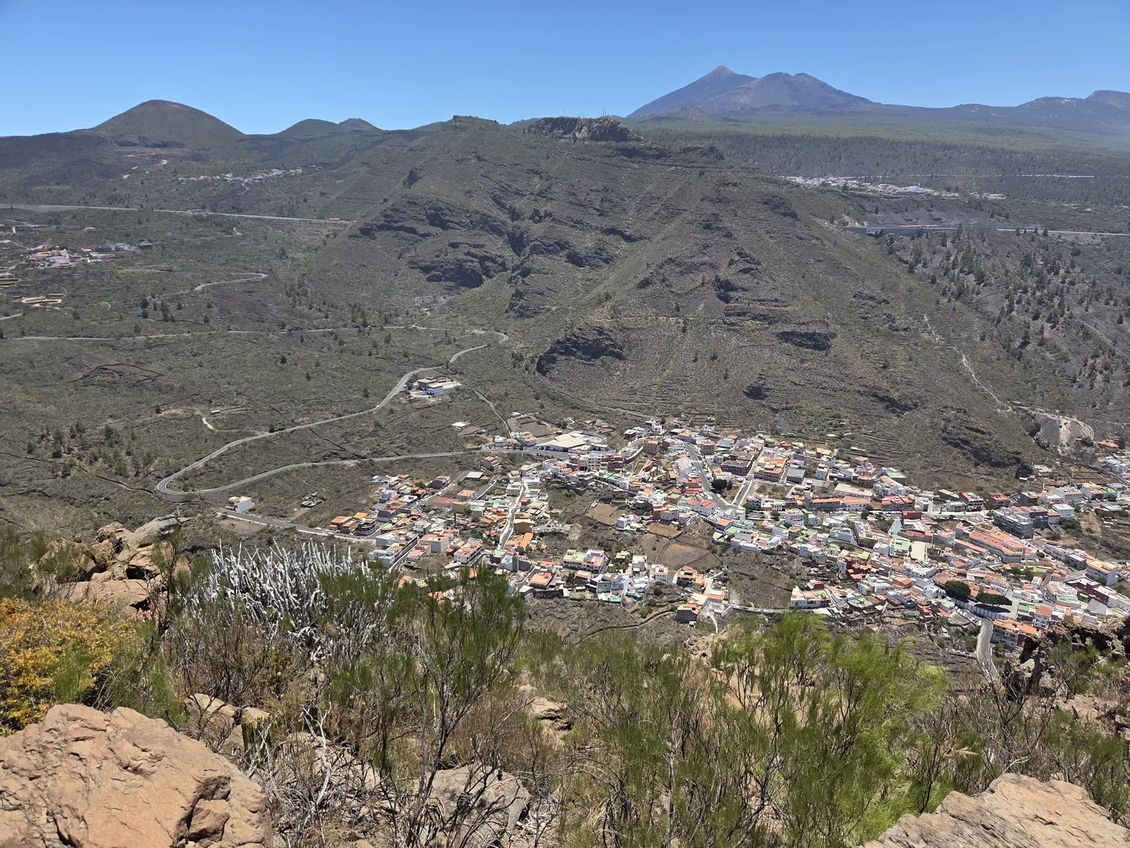 Tamaimo village beneath mountain slopes, with Teide visible in the distance from Guama