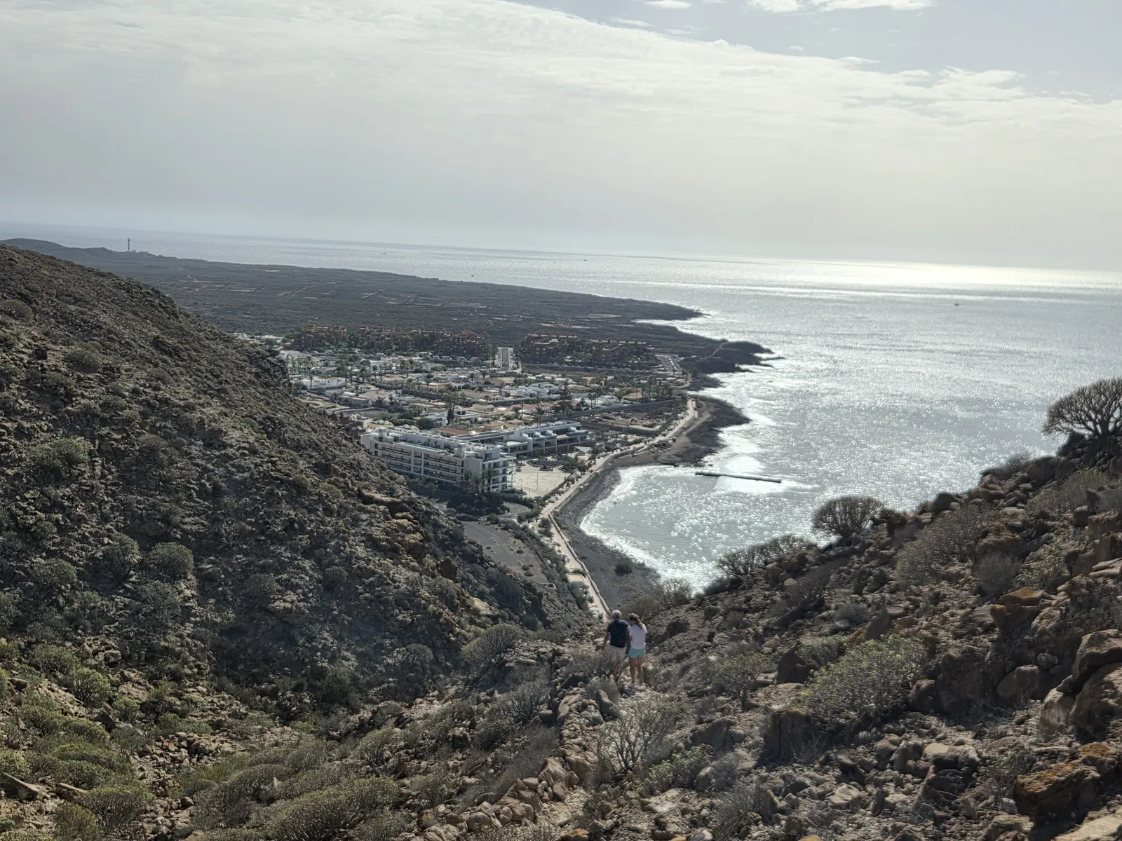 Palm-Mar and its curved shoreline below a steep rocky hillside